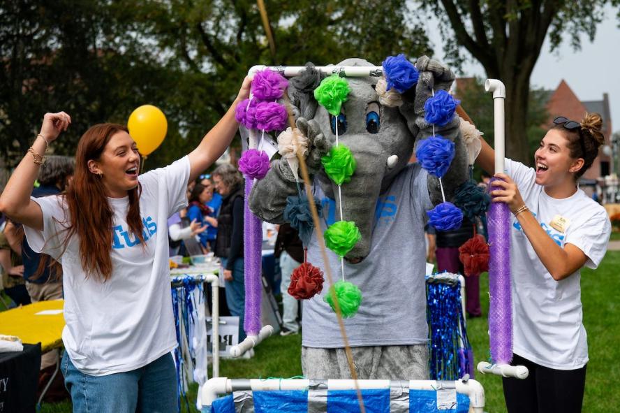 Students from the Tufts School of Physical Therapy host an interactive car wash activity at Tufts Commuity Day with Jumbo paritcipating in the activation. 