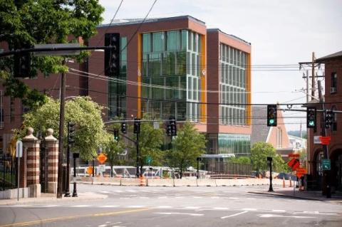 A new Tufts University building, still under construction, overlooks an intersection with other parts of campus visible around it. Joyce Cummings Center, a new academic hub on the Medford-Somerville campus, is slated to open in early 2022.