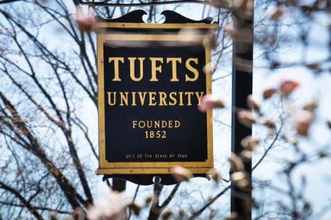 Tufts University sign beside a flowering tree. Tufts emergency response grants are offered to community nonprofits in Medford, Somerville, Boston, and Grafton.