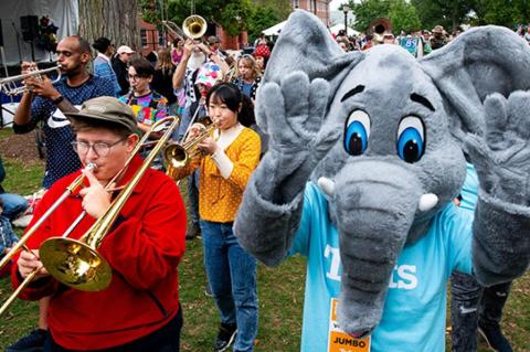 Tufts mascot Jumbo leads a parade of horn-playing musicians at Tufts Community Day