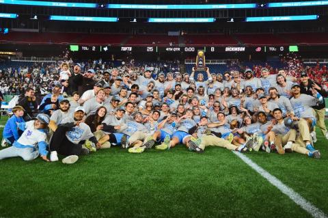 The Tufts lacrosse team including coaches line up with the NCAA trophy after the game. The undefeated men’s lacrosse team wins its second straight national championship