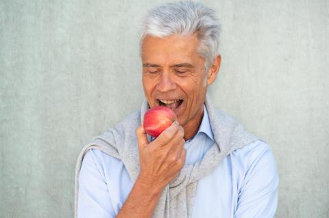Man taking a bite out of an apple