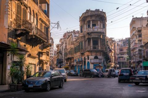 A city street in Tripoli, Lebanon, crowded with older building and cars parked on the street