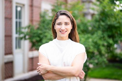 Xandra Kredlow stands in front of a brick building with her arms crossed