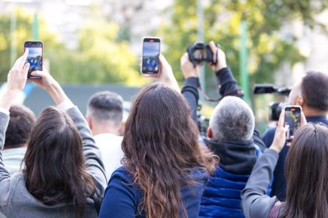 a crowd filming on phones